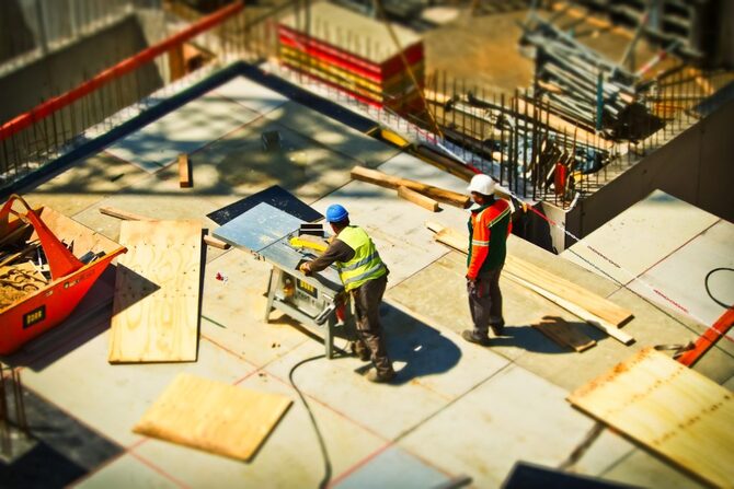 2 vakmannen bezig met het bouwen van woningen