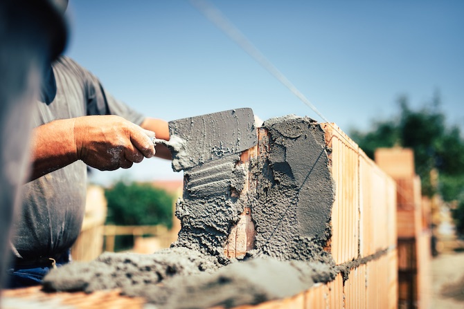 Vakspecialist is bezig met het metselwerk